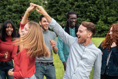 Değişik genç arkadaşların dinamik portresi dans ediyor ve dışarıda birlikte dönüyorlar. Yaz kutlamaları sırasında gerçek neşe, hareket ve çok kültürlü dostluğu gösteren otantik yaşam tarzı.