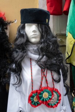 Geleneksel beyaz takım elbise ve üç renkli kolye ve manken üzerinde Aziz Agatha madalyaları. Sicilya, Catania 'daki Aziz Agatha festivalinde giyilen tipik kostüm..