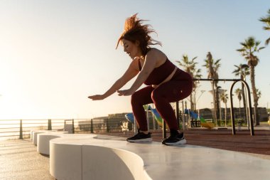 Artı, tropikal açık hava spor salonunda fonksiyonel antrenman yapan bir sporcu.