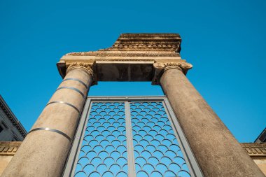 Piazza Stesicoro 'daki Roma Amfitiyatrosunun girişinde antik sütunlar ve dekoratif bir kapı yer alıyor..