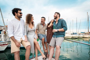 Bir grup neşeli arkadaş, yat limanında eğlenceli bir yat gezisinin tadını çıkarıyorlar. Rahatlamış yaz tatili titreşimleri, kahkahalar ve deniz seyahati maceraları. Deniz kıyısındaki dostluk ve mutluluk.