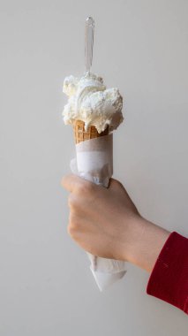 Lezzetli bir waffle külahını bir kepçe kremalı beyaz vanilyalı ya da hindistan cevizli dondurmalı. Sıcak bir yaz günü için ferahlatıcı mükemmel bir dondurulmuş tatlı. Sade bir arkaplanda izole edilmiş.