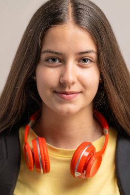 Kırmızı kulaklık takan mutlu ve kendine güvenen bir genç kızın güzel bir yakın çekim portresi..