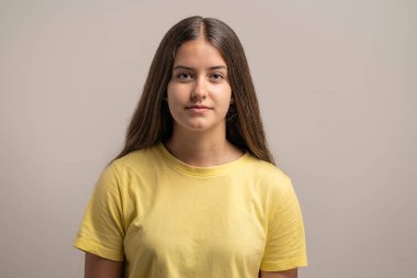 Tamamen tarafsız ve boş bir ifadeyle genç bir kızın portresi. Kimlik fotoğrafları, sabıka fotoğrafı konseptleri ya da 