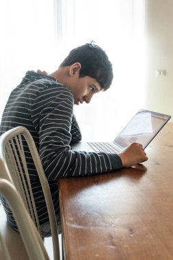 Yorgun bir öğrenci, uzun saatler boyunca dizüstü bilgisayar kullanırken boyun ağrısı ve stresten muzdarip. Uzaktan öğrenmenin getirdiği teknoloji boynu, patinaj ve sağlık sorunlarını anlatıyor.