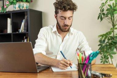 Genç ve yakışıklı bir öğrenci ya da sakallı bir serbest çalışan, bir günlüğe yazarken, sınava çalışırken ya da ev ofisinde bir proje planlarken konsantre olur..