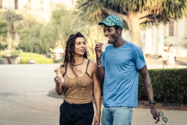 Birlikte dondurma yiyen mutlu, çok kültürlü bir çift. Sevgi, dostluk, çeşitlilik, otantik yaşam tarzı, eğlence, tatil ve mutluluk dolu bir yaz anıydı..