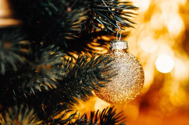 Noel mücevherleri ağaçta asılı, altın ve yeşil Xmas arka planı, altın Noel balosu ayrıntıları