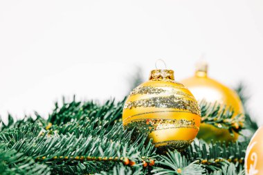 Noel topları ve beyaz arka planda köknar dalları. Altın mücevherlerle dolu Xmas arkaplanı