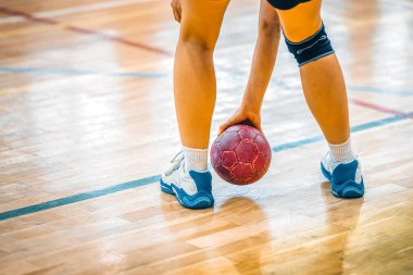 Hentbol, topu tutan oyuncu, kapalı alanda takım sporu.