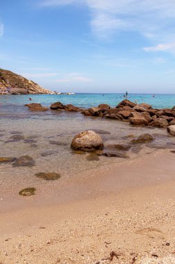 Sant Andrea, Elba Adası, İtalya - 06 Haziran 2022 Beyaz kumlu plajda su sporlarından keyif alan turistler Sant Andrea, Elba Adası, İtalya 'da şnorkelle yüzmek ve rahatlamak için mükemmeller.