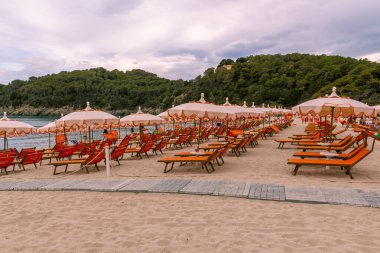 Akşamları Fetovaia, Elba Adası, Toskana, İtalya 'nın ikonik plajlarında boş güneşlikler.