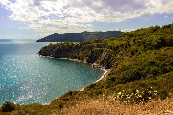 stock image High angle view over Acquarilli Beach, a dark sand beach for nudist situated in the gulf of stella, Elba island, Italy. 