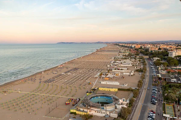 Gün batımında boş plaj sandalyeleriyle Rimini İtalya Limanı 'ndaki panoramik dönme dolaptan görülen kıyı şeridi manzarası..