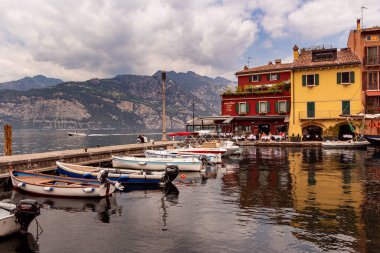 Malcesine, Garda Gölü, İtalya - 01 Haziran 2021 Malcesine Limanı 'ndaki renkli evler ve balıkçı tekneleri. 