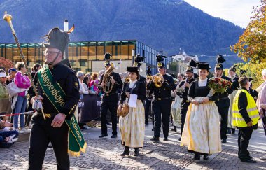 Meran, Güney Tyrol, İtalya - 15 Ekim 2023 Geleneksel Şükran Günü sokak geçidi Merano üzüm festivalinde yerel folklor müzik grupları. 