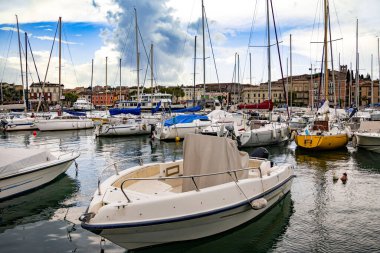 Desenzano, Garda Gölü, İtalya - 25 Mayıs 2024 Renkli balıkçı tekneleri ve Desenzano Limanı 'ndaki evler. 