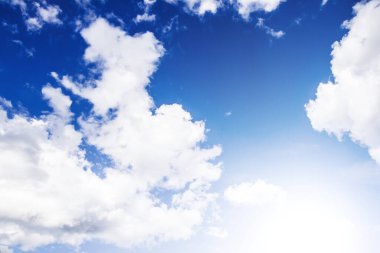 Cennet arka planı. Bulutlu bir arka plan. Gökyüzü arka planında kabarık bulutlar. Bulut manzarası. Gökyüzünde parlak güneş ışığı. Gün ortası yüksek güneş.