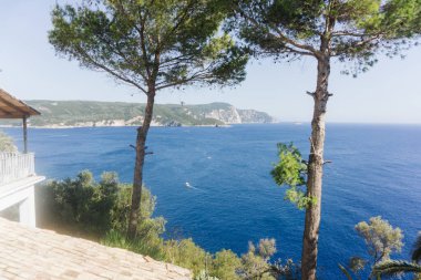 Dibinde okyanus olan yüksek uçurum. Korfu Adası - Yunanistan. Şeffaf turkuaz deniz. Egzotik tatil manzarası