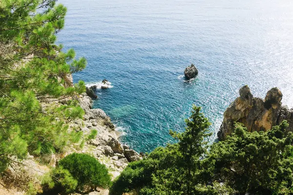 Dibinde okyanus olan yüksek uçurum. Korfu Adası - Yunanistan. Şeffaf turkuaz deniz. Egzotik tatil manzarası