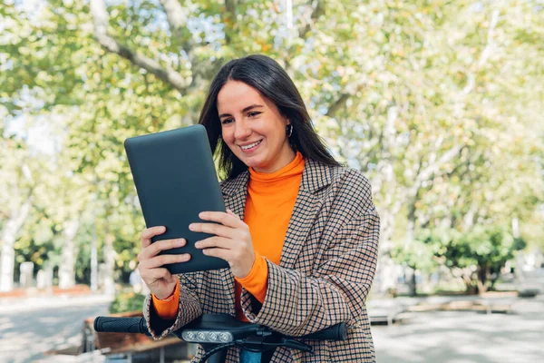 Young student woman or business woman in a casual style using a digital tablet outdoors