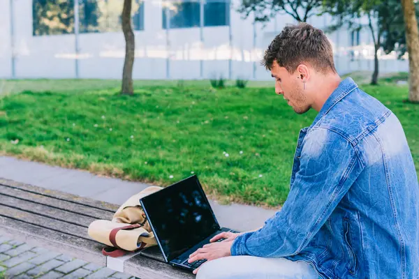 Вид Сзади Молодого Человека Работающего Ноутбуком Сидящего Скамейке Городском Парке — стоковое фото