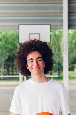 Basketbol sahasında mutlu bir çocuğun fotokopi çekilen dikey portresi