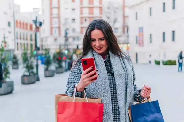 Güzel Olgun Bir Kadın Sokakta Alışveriş Torbaları Taşırken Telefon Kullanıyor — Stok fotoğraf