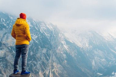 Karlı dağda kalın giysiler içinde bir adamın arka görüntüsü. macera yolculuğu ve ekipman.