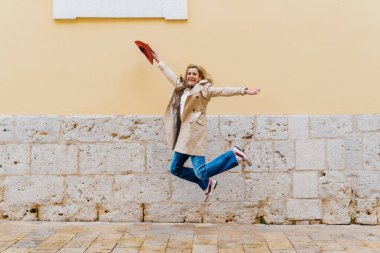 Şehirde atlayan mutlu iş kadını. Özgürlük, kutlama, neşe, başarı ve akıl sağlığı kavramı.