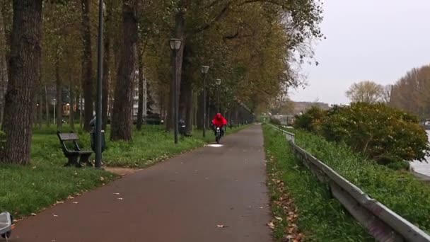 Hombre Impermeable Casco Barrido Por Viento Rojo Monta Una Bicicleta — Vídeo de stock