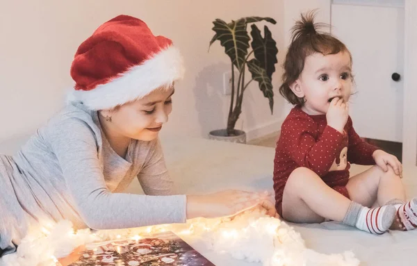Две Красивые Маленькие Кавказские Сестрички Шляпе Санта Клауса Рождественский Календарь — стоковое фото