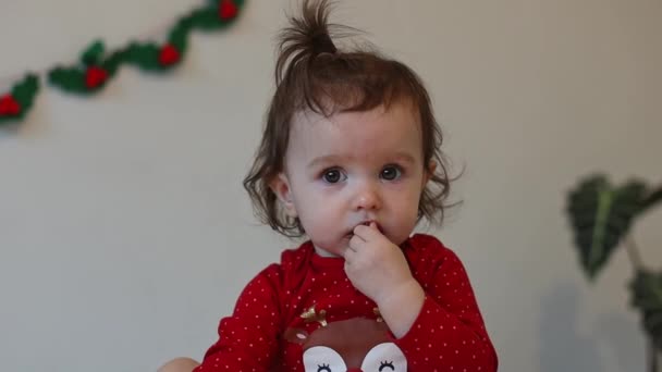 一个漂亮的小女孩 头戴马尾辫 身穿圣诞紧身衣 坐在床上 吃着日历上的巧克力糖果 慢镜头特写 — 图库视频影像