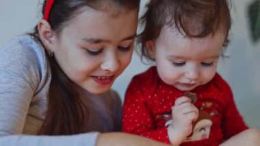 Kafasında at kuyruğu olan güzel beyaz bir kız, yeni gelen takvimden çikolatalı şeker yiyor ve ablası onun oynayışını ve gülümsemesini yavaş çekimde yakından izliyor..