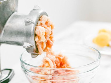 Mermer bir masada cam bir tabakta kıyma ile elle öğütücü. Yakın plan, ev yapımı kıyma ve sağlıklı beslenme kavramı..