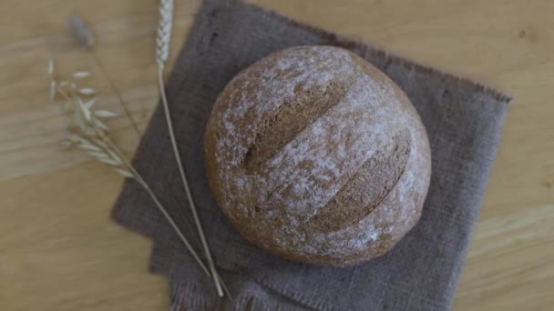 Один Круглий Свіжий Житній Хліб Волокном Мішкуватій Серветці Трьома Вухами — стокове відео