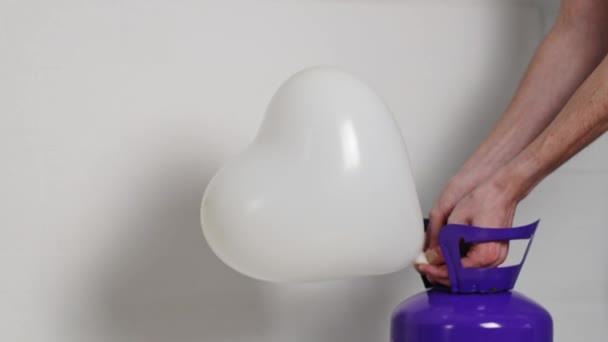 Young Caucasian Unrecognizable Man White Shirt Inflates White Heart Balloon — Stockvideo