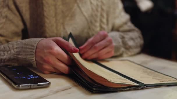 Young Caucasian Unrecognizable Man Leafing Paper Menu While Sitting Table — Videoclip de stoc