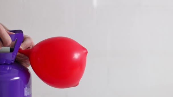 Young Caucasian Unrecognizable Man White Shirt Inflates Balloon Red Heart — Stock Video