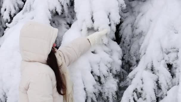 Młoda Kaukaska Dziewczyna Białej Kurtce Kapturem Dzianinami Potrząsa Śniegiem Gałęzi — Wideo stockowe