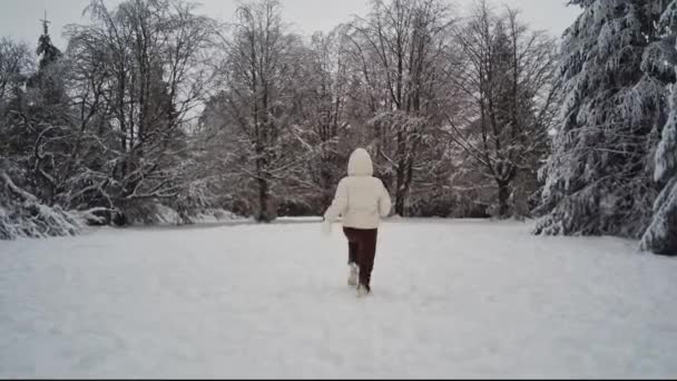Young Caucasian Girl White Jacket Hood Brown Pants Back Runs — Stock Video
