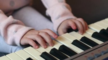 Kafkasyalı küçük bir kız elinde gitarla ipleri koparıyor notaları öğreniyor, yakından bakıyor. Müzik eğitimi kavramı.