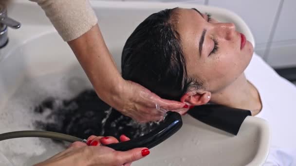Cabeleireiro Jovem Mulher Caucasiana Está Enxaguando Cabelo Longo Shampoo Marrom — Vídeo de Stock