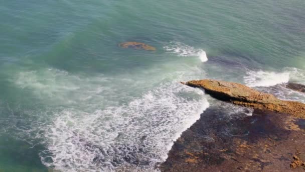 フランスのノルマンディーで干潮の後に岩の多い海岸に対して北の海の白い泡で波を走らせ ゆっくりとした動きで上から近い眺め 旅行時間 夏時間の概念 — ストック動画