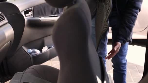 코카서스 남자는 자동차 세탁을 하면서 자동차 내부에 매트를 합니다 — 비디오