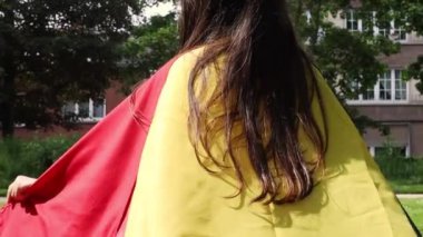 Arkadan güzel bir kız Belçika bayrağını sallayarak koşuyor. Güneşli bir yaz gününde, yakın çekimde. Belçika Günü konsepti.