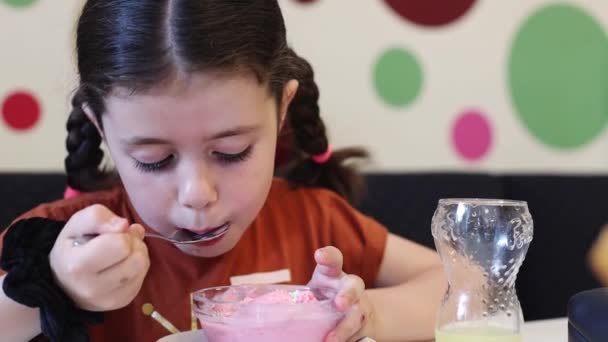 Une Belle Petite Fille Brune Caucasienne Avec Deux Nattes Mange — Video