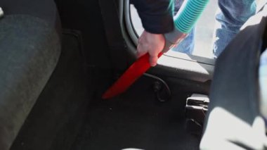 Genç bir Kafkasyalı tanınmaz halde. Kamuya açık bir oto yıkamada arabasını süpürüyor..