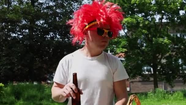 Jeden Młody Wesoły Mężczyzna Belgijskich Okularach Przeciwsłonecznych Czerwonej Peruce Pijący — Wideo stockowe