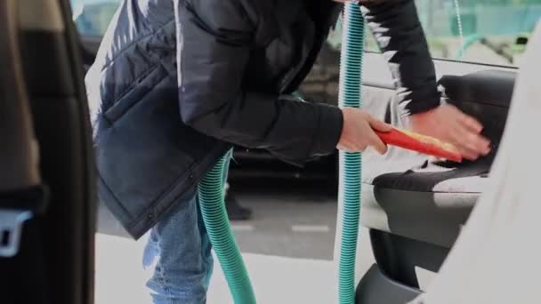 一个年轻的白人男子正在用公共洗车的方式 用吸尘器把他的车的前门吸空 这是一个近距离的侧视 — 图库视频影像